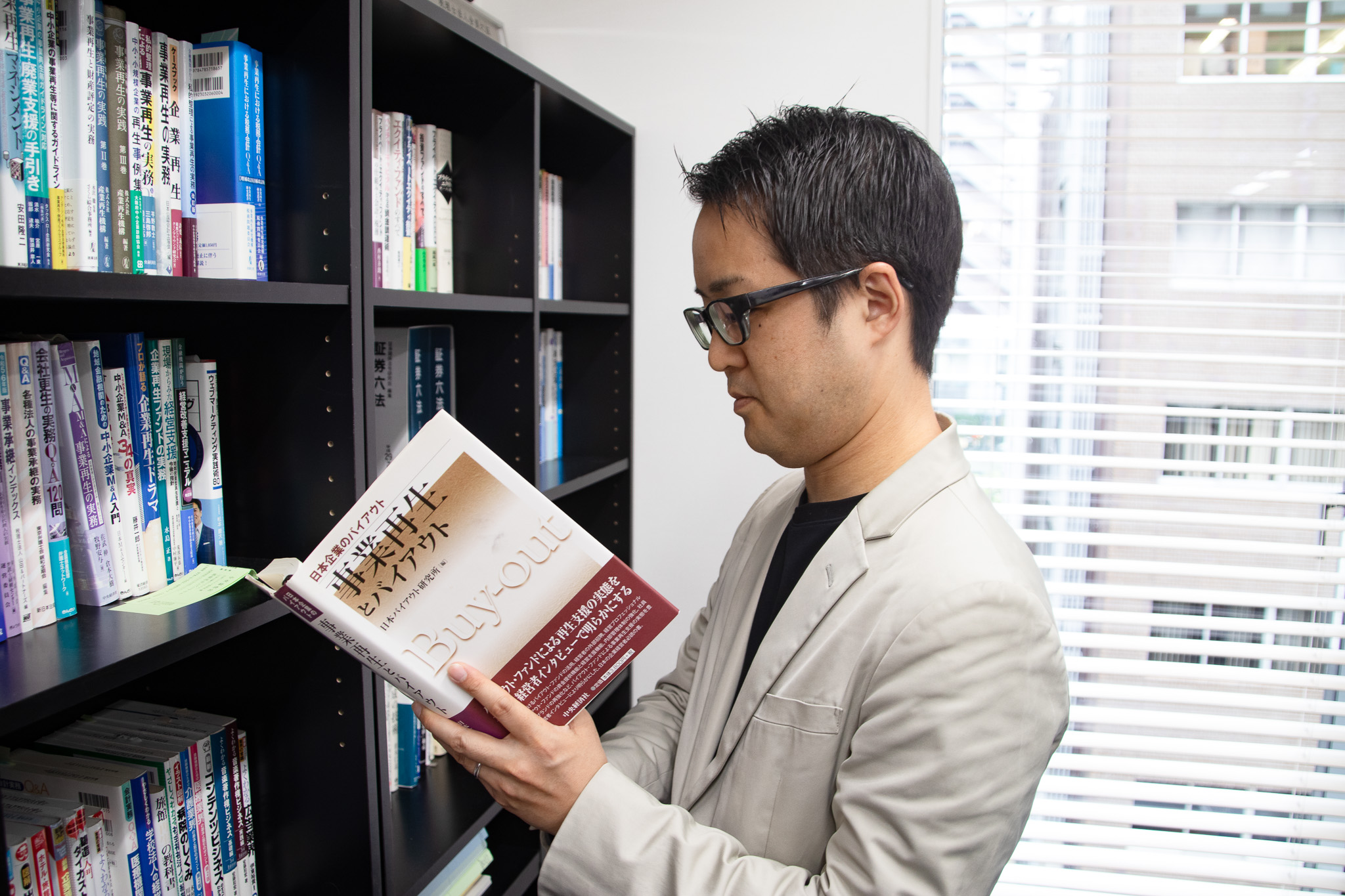 J-TAP_オフィス訪問_本を読む手塚編集長